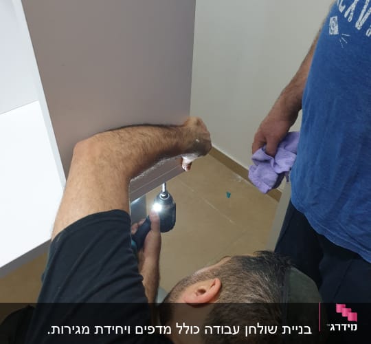 נגר משתמש במברגה להרכבת רהיט